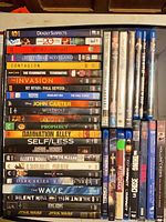 Full view of stacked DVDs in drawer showing titles and cases