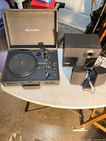 Turntable, subwoofer and two speakers displayed on table