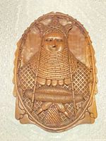 Front view of carved hardwood plaque showing detailed human portrait and border