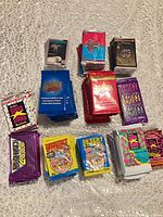 Overview of multiple stacks of sealed trading card packs including Desert Storm, Branson, Vertigo, MusiCards, Deathwatch 2000