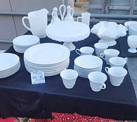 Full view of all white dinnerware and milkglass pieces on table