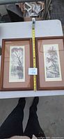 Both framed prints side by side with tape measure showing size