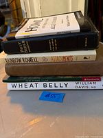 Stack of five books showing visible titles and spines