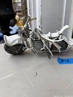 Left side view of handmade wire motorcycle showing overall construction and white padded areas