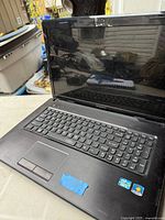 Open Lenovo G780 showing screen, keyboard, touchpad, stickers