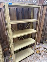 Front view of beige metal shelving unit showing all five shelves and frame construction