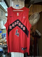 Front view of red Toronto Raptors Nike jersey showing team wordmark, number 4, Sun Life patch, size tag at hem