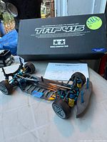 Overall view of partially assembled TRF415 chassis, instruction sheet and kit box