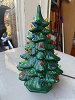 Front view of green ceramic Christmas tree with multicolored peg lights