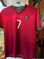 Front view of red striped Portugal jersey showing crest and number 7