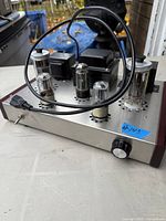 Oblique view of tube amplifier showing tubes, transformers, power switch and volume knob