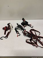 Group shot of two Erickson retractable ratchet straps and two Husky tie-down straps