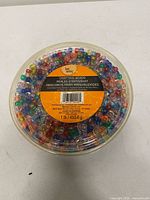 Top view of sealed tub showing multicolor pony beads through clear lid