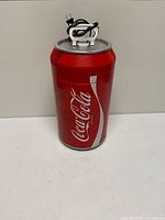 Front view of red Coca-Cola can-shaped mini fridge with power cord