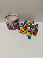 Bucket and pile of colourful wooden blocks
