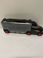 Left side view showing overall truck carrier with grey side panel and red wheels