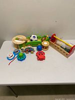 Group shot of all 11 wooden toddler toys on table