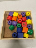 assorted colored wooden beads inside wooden box