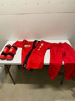 Full view of jacket, pants and shin guards laid on table