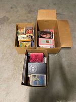 Three cardboard boxes filled with assorted books