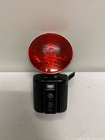 Front view showing red lens and black body