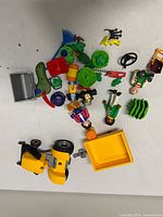 Group of figures, tools, plants, tractor parts on tabletop