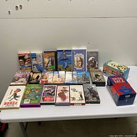 Full lot of VHS tapes on folding table showing all items including both box sets