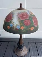 Full view of lamp front, floral glass shade and brown metal base