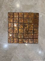 Square gold-leaf glass mosaic tile sheet showing 36 tiles