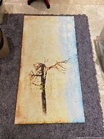 Full view of the abstract tree canvas print lying on a rug