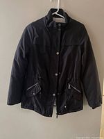 Front view of black jacket on hanger