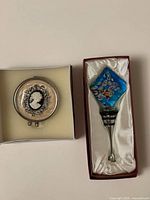 Murano bottle stopper in original satin-lined box beside cameo pill box in foam-lined box