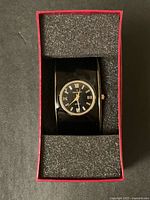 Watch in box showing dial and cuff band