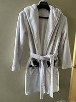 Full front view of white hooded robe on hanger showing overall style, belt and panda pockets
