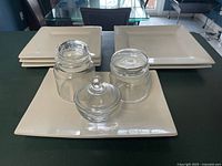 Group shot of all plates, platter and three glass jars