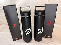 Front view of both Peloton glass water bottles with boxes