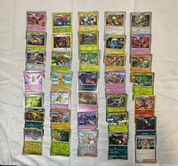 Four columns of assorted Pokémon TCG cards laid out on cloth, showing variety and condition
