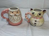Front view of both ceramic character mugs