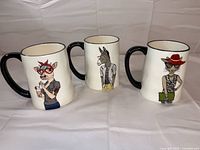 Front view of three mugs showing graphics and handles