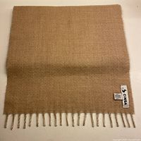 Full view of pale tea side showing label and fringe