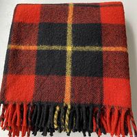 Folded blanket showing plaid pattern and fringe