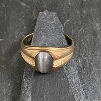 Front view of 10K gold ring showing grey tiger eye stone and textured shoulders