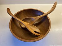 Salad bowl with spoon and fork resting inside