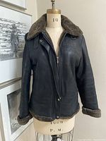 Full frontal view of Brown's dark brown shearling jacket on dress form