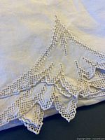 Corner detail of crocheted lace on linen tablecloth