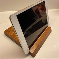 Teak stand holding a tablet to illustrate function