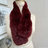 Full view of red rabbit fur scarf draped on dress form
