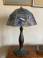 Full view of lamp showing stained glass shade and metal base