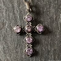 Close-up of amethyst cross pendant showing stones and metal