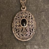 Front view of 825 silver oval locket with onyx and marcasite